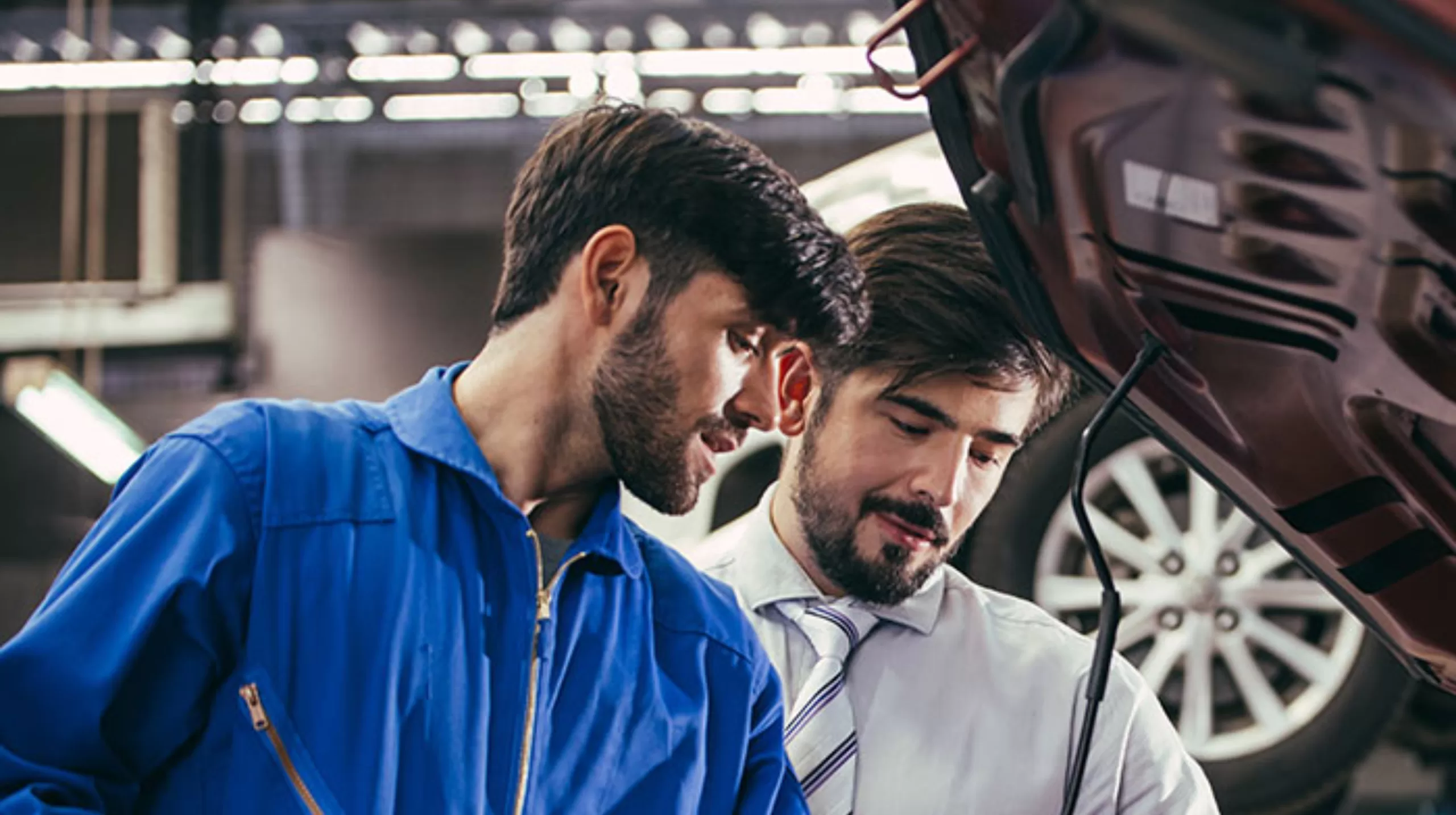 Mecânico realizando vistoria automotiva em veículo com cliente durante inspeção para alteração de característica em Bayeux