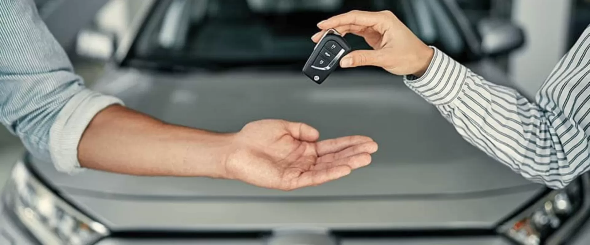 Entrega de chave de carro durante processo de compra e venda de veículo, representando vistoria veicular em Sapé para transferência segura.
