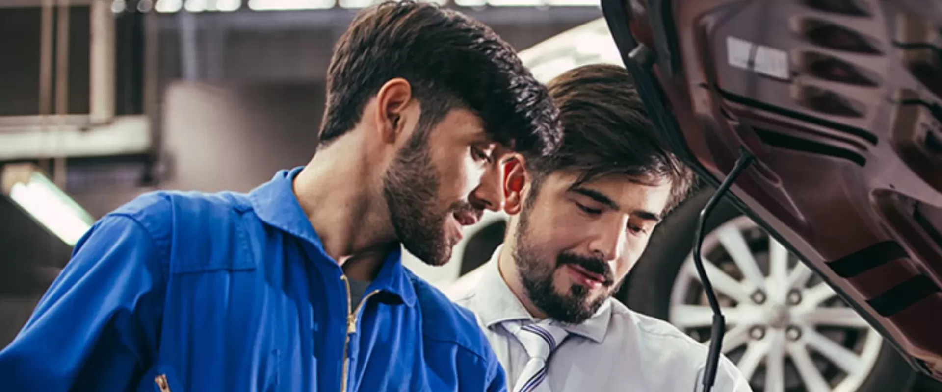 Mecânico realizando vistoria automotiva em veículo com cliente durante inspeção para alteração de característica em Bayeux
